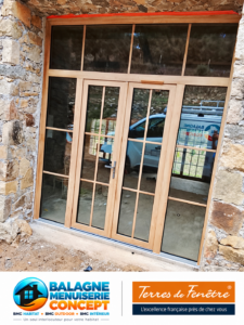 Menuiseries PVC Eclea finition Woodec chêne Turner Malt sur une façade en pierre à Cassano